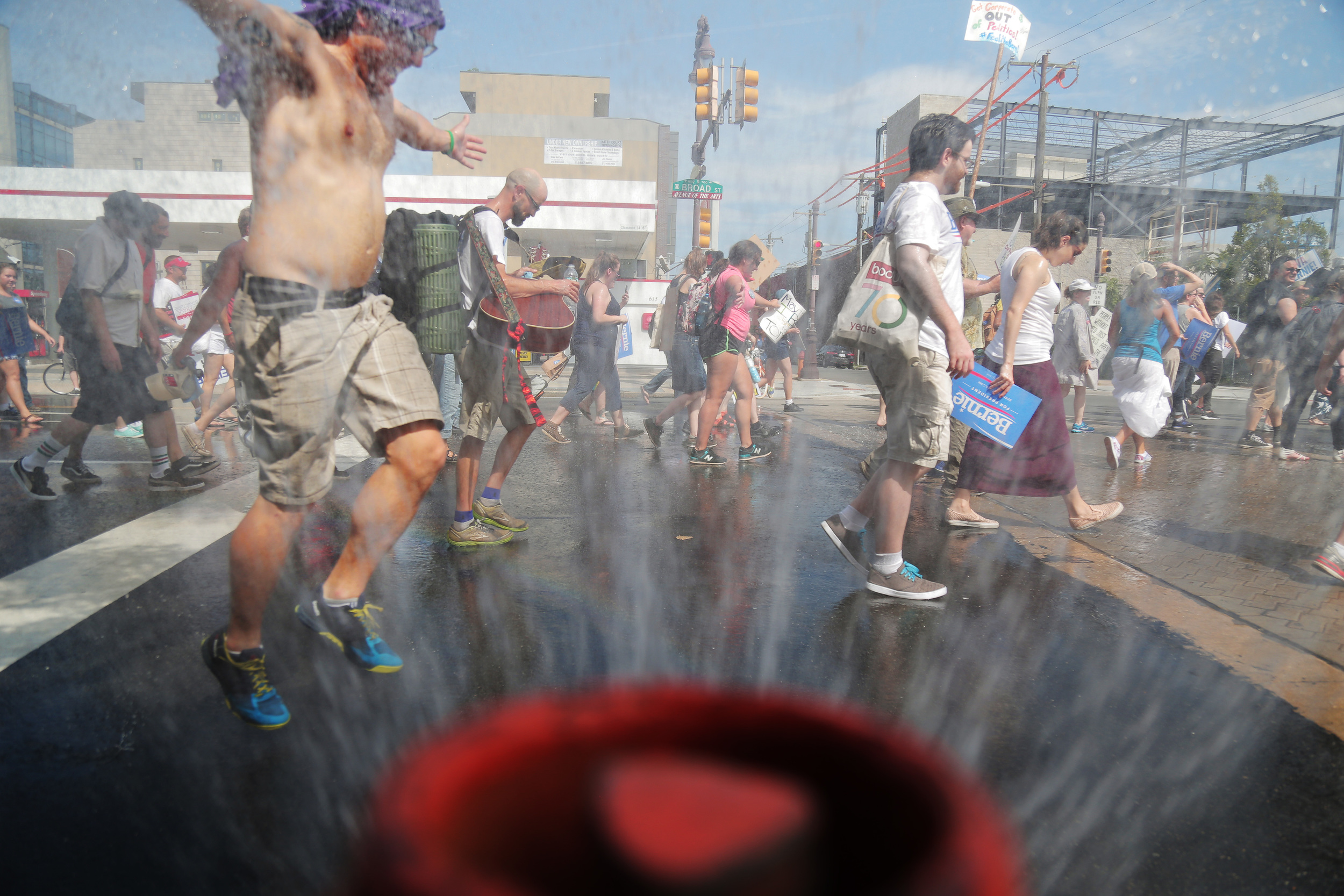  Supporters of Bernie Sanders march through the spray from a fire hydrant in downtown Philadelphia the day before the Democratic National Convention begins. 