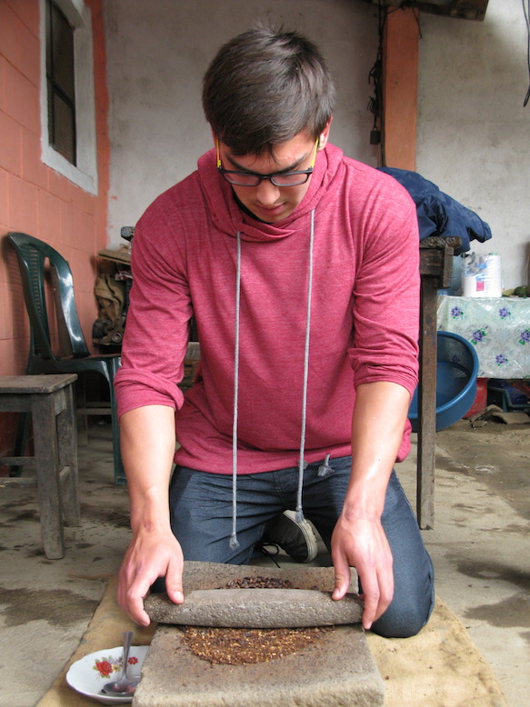 Another participant grinds the freshly roasted beans.
