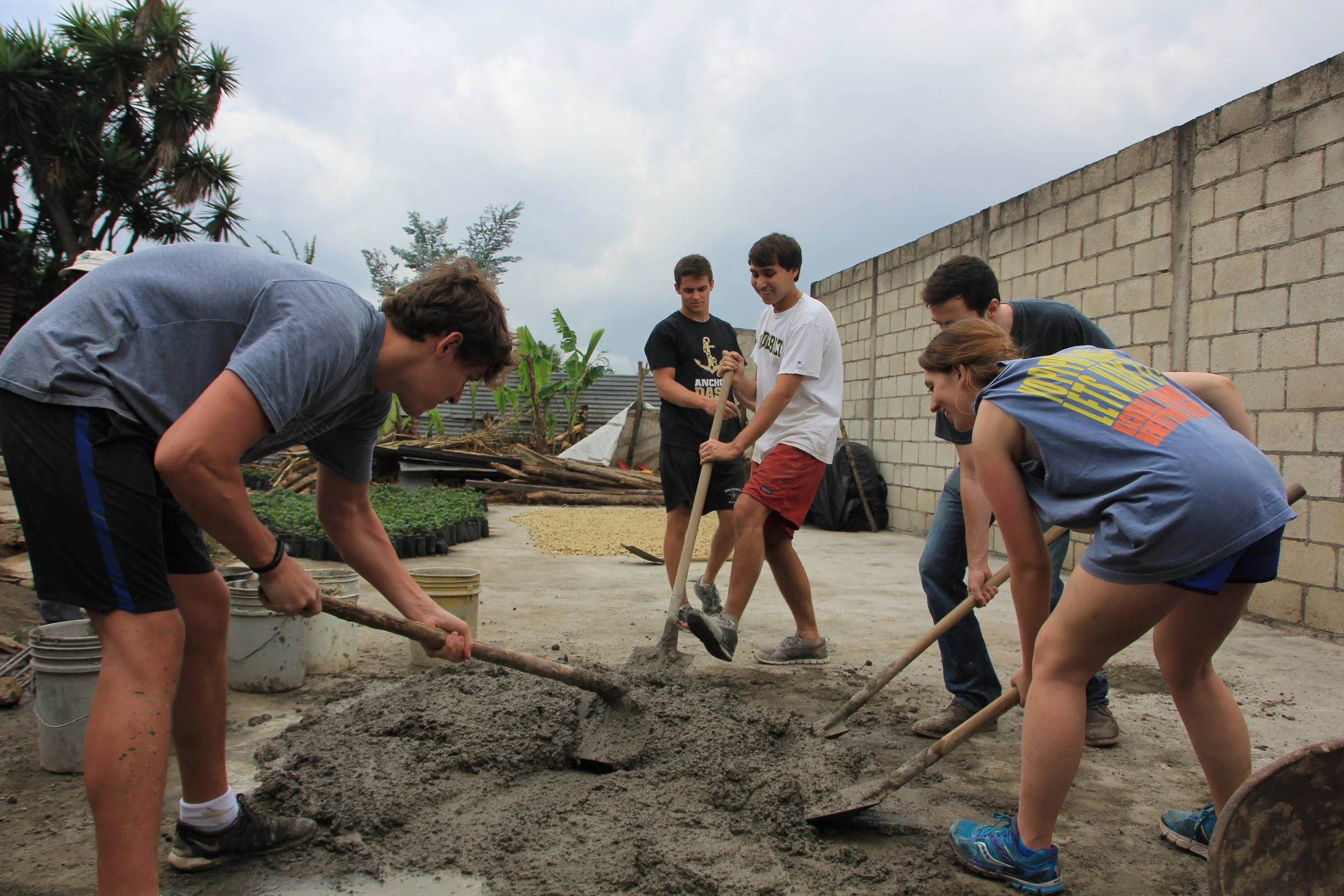Student's mixing cement to build a wall with Juan Carlos to protect his drying patios.