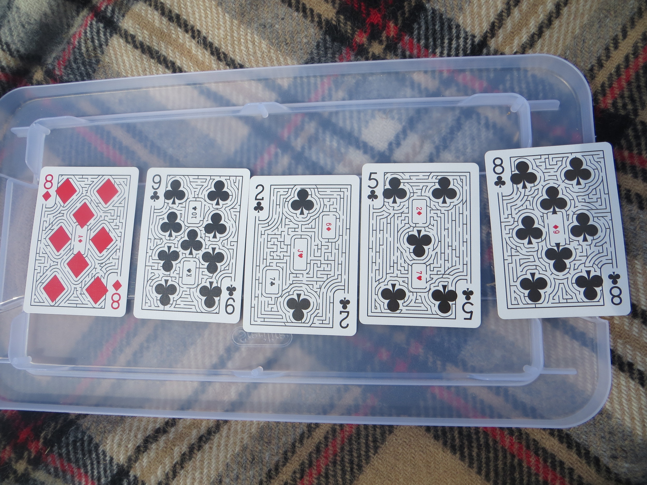 Each card is a maze, and the entire deck is a maze too. You start in a corner and, when you pass through the icon of another card, you jump to that card. The goal is to get from one joker to the other.