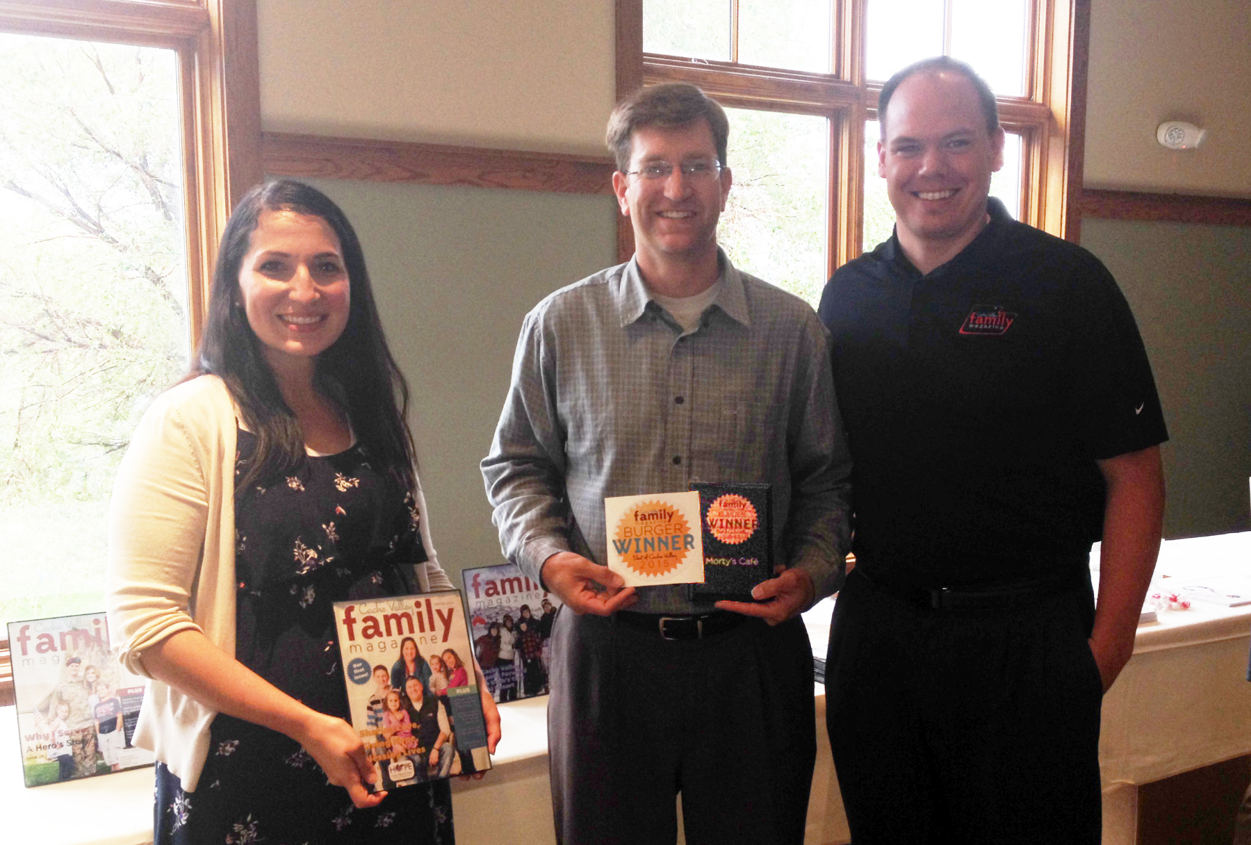 Preston Parker, Co-Owner of Morty's Cafe, receiving the "Best Burger" award from Cache Valley Family Magazine Co-Founders, Emily and Bryan Buckley.