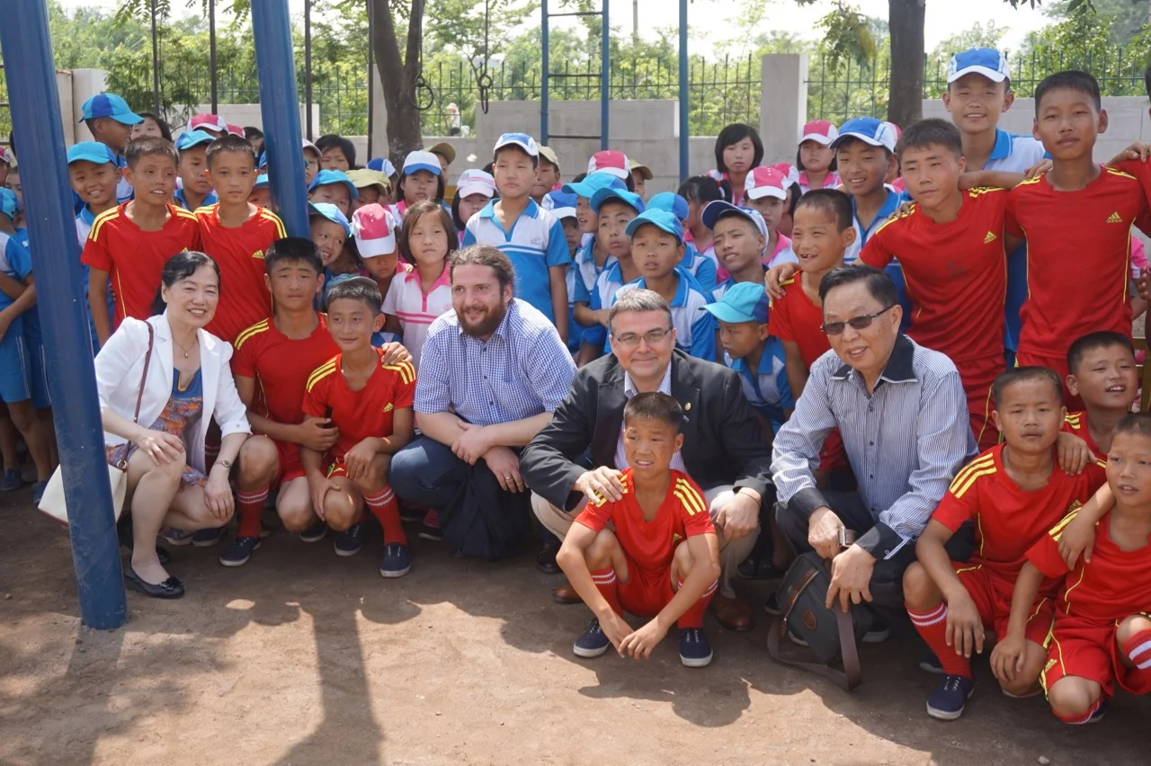 Rotarians Randal and NIkola along with Dr. Chen Qun and Shen Keqiao say farewell to the students and football players at Mirim School.