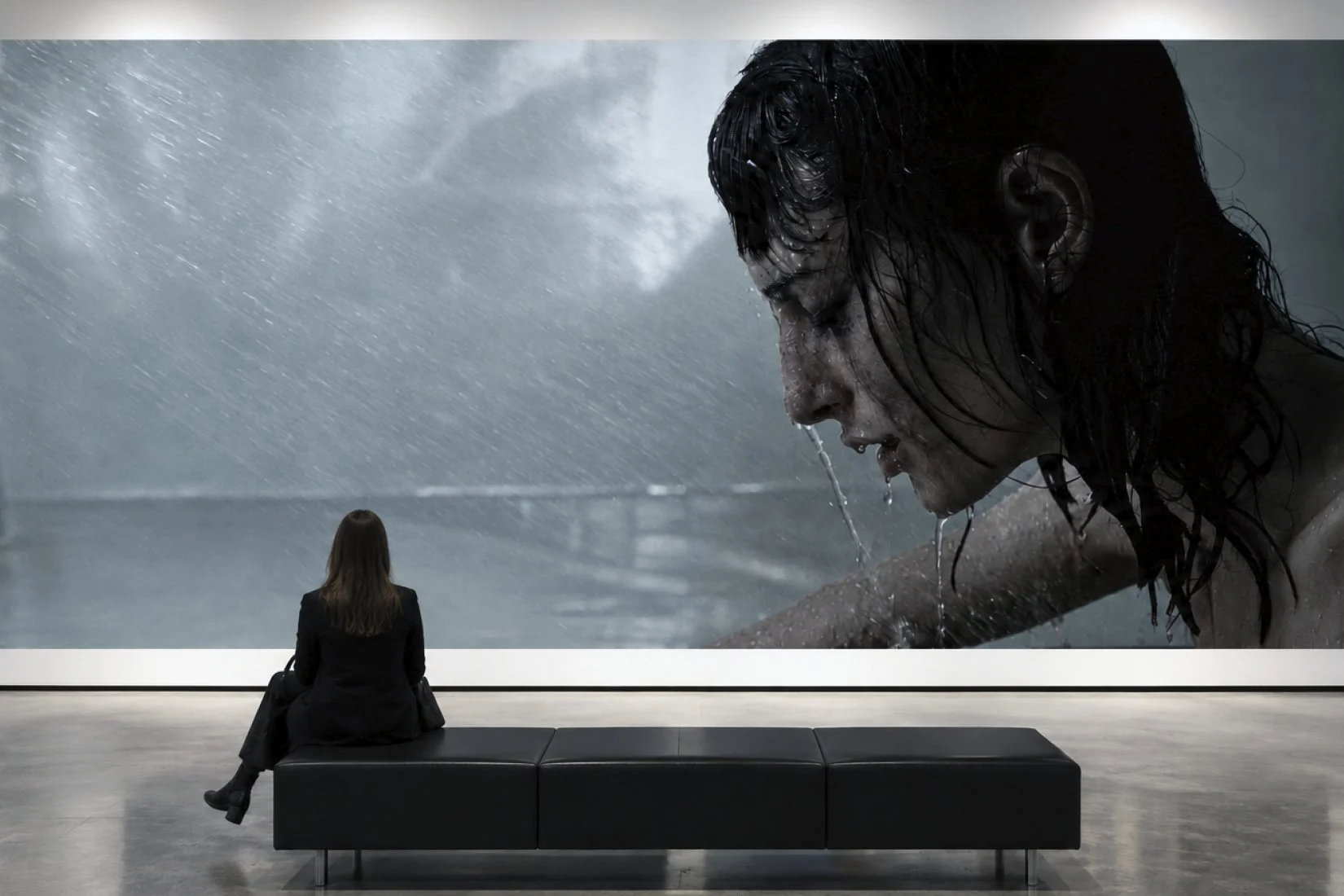 Gallery visualisation showing a large rain-soaked portrait from Slow Plumbing by Javier Vallhonrat.