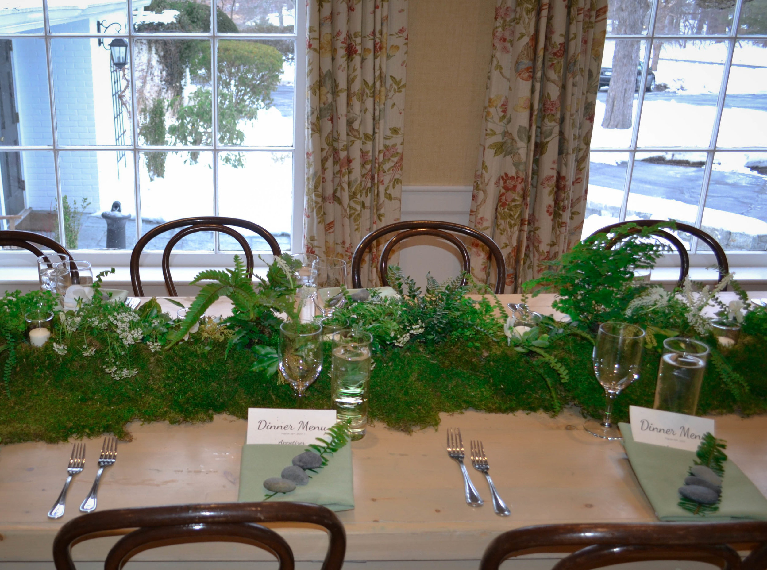 Lush 6' moss table runners were created and topped with votives, several fern varieties, clover, foraged andromeda and seasonal white flowers such as muscari, alyssum and pansies
