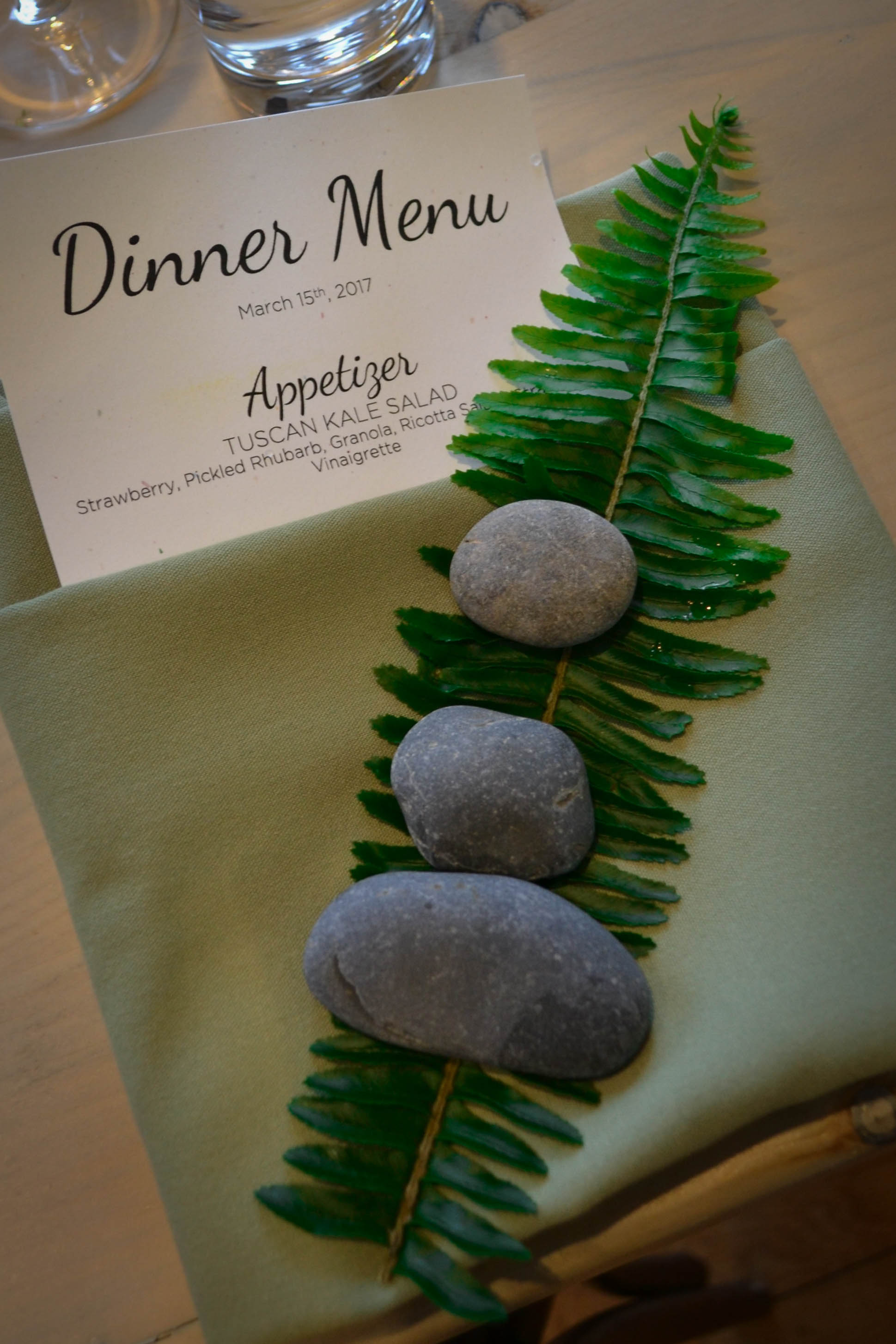 Three meditation stones and a single fern sprig were placed at each table setting.