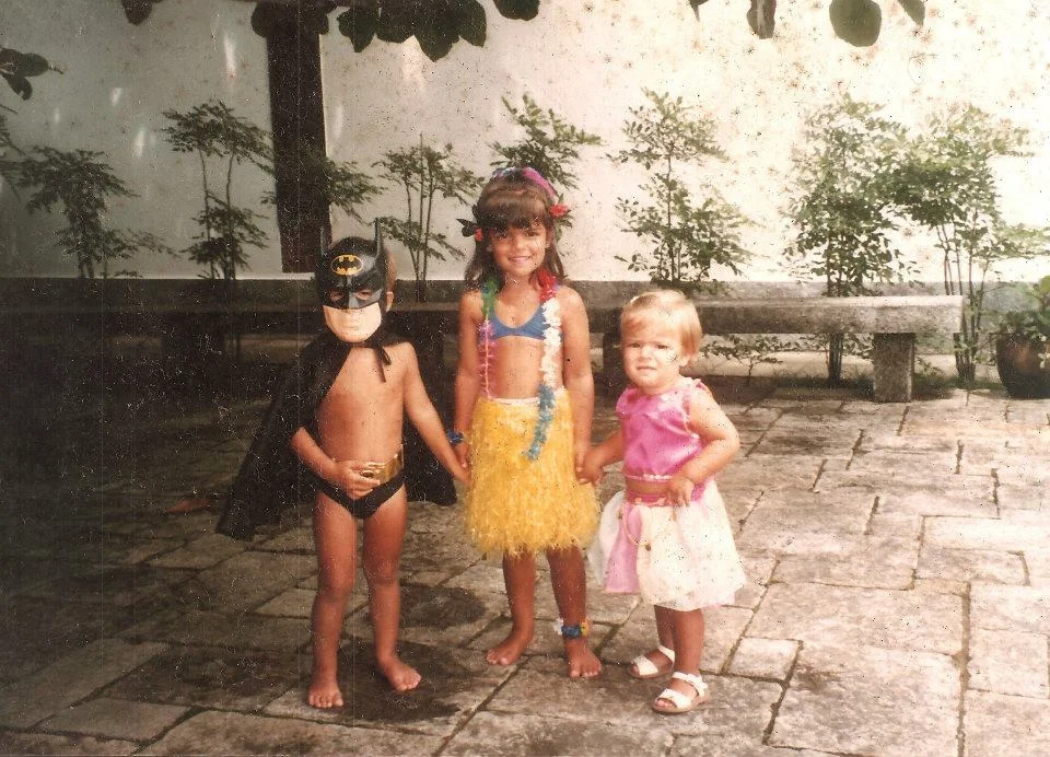 A young Ana (middle) with her brother and sister preparing for Carnival.