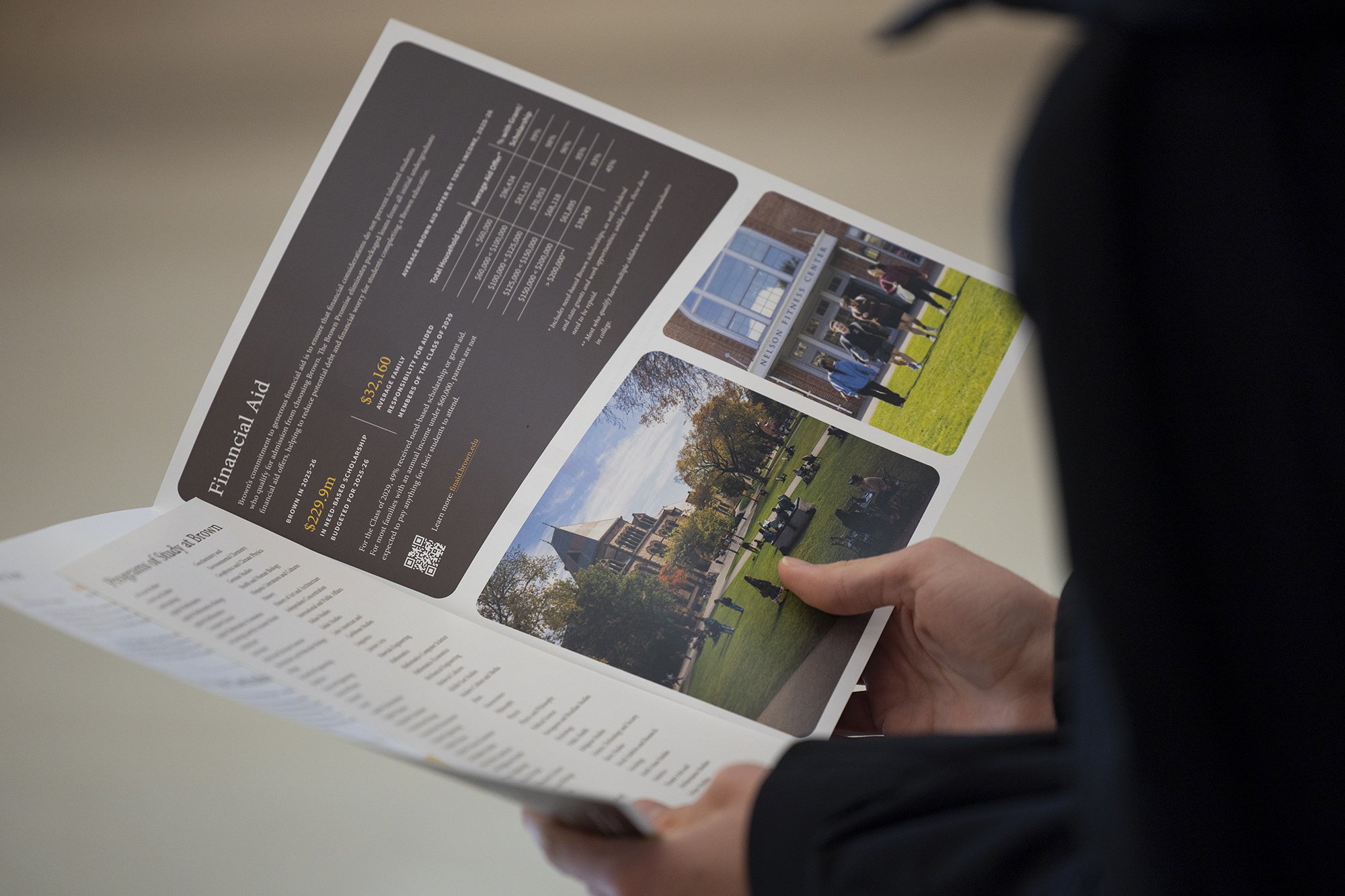 Person holding a brochure with financial aid information