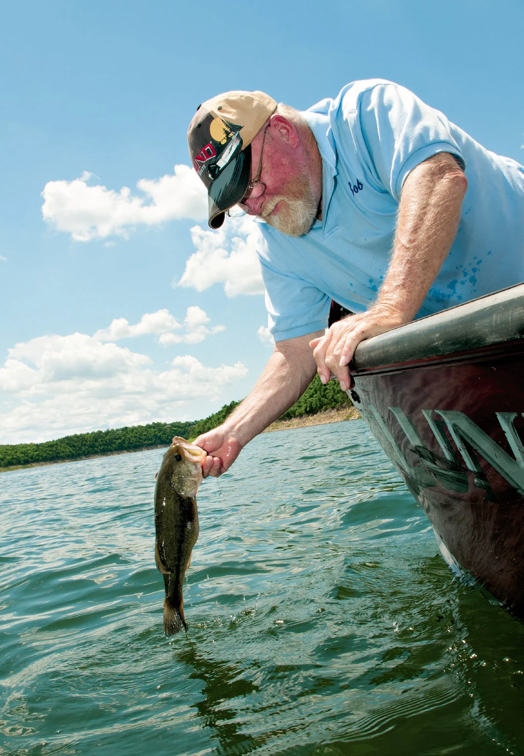 Local fishing guide Bob Bochert lips a largemouth bass from the waters of Bull Shoals Lake. He and his wife, Shirley, retired to the lake about 13 years ago, and he enjoys fishing for bass, crappie and walleye.