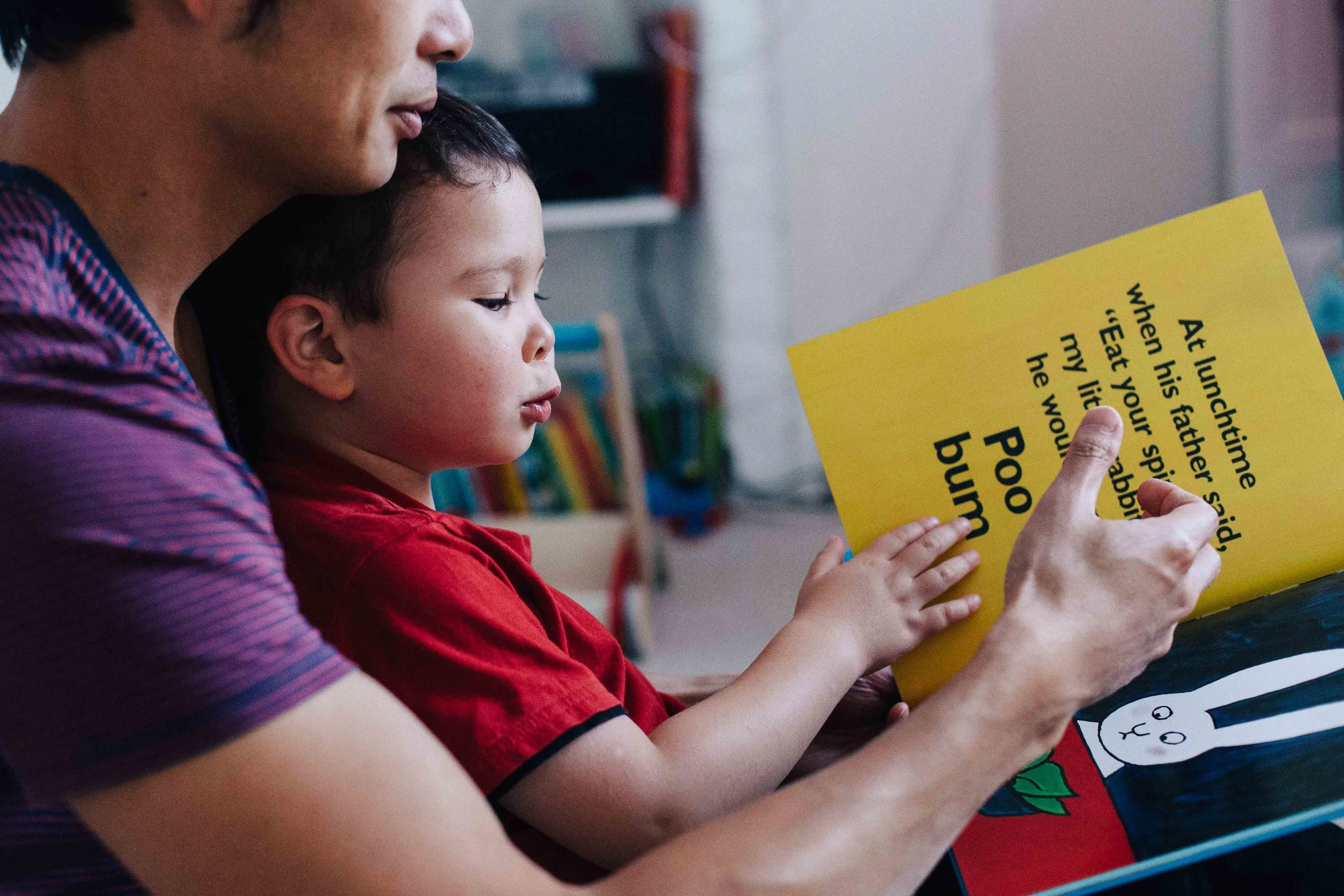 Child reading Poo Bum book with his father