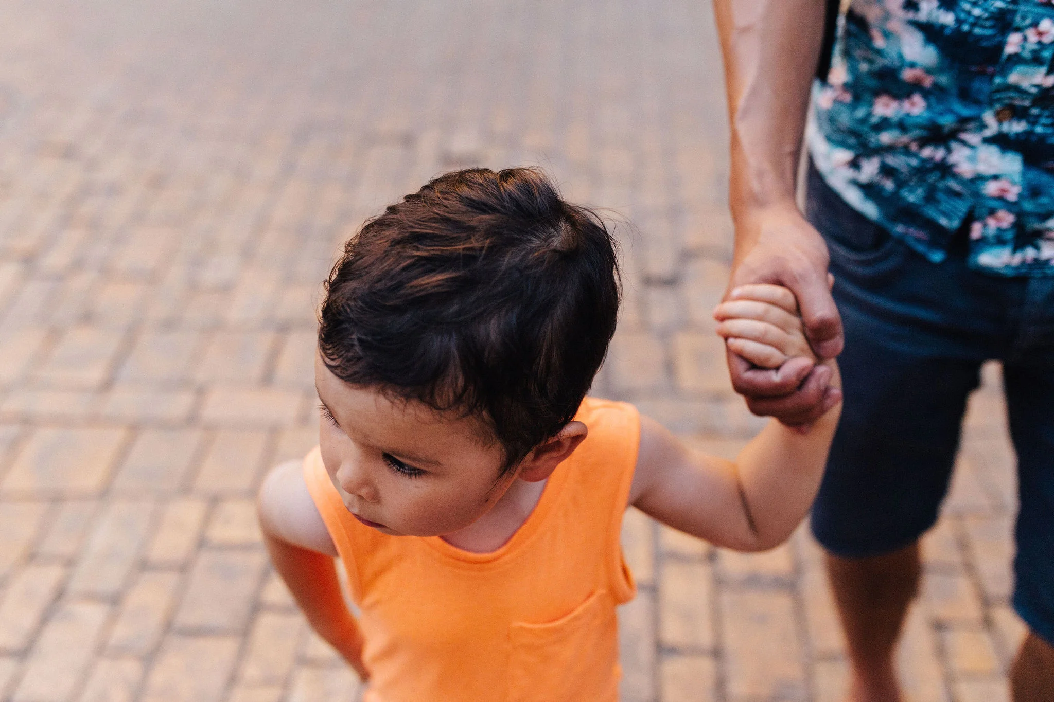 Little boy holding his father’s hand
