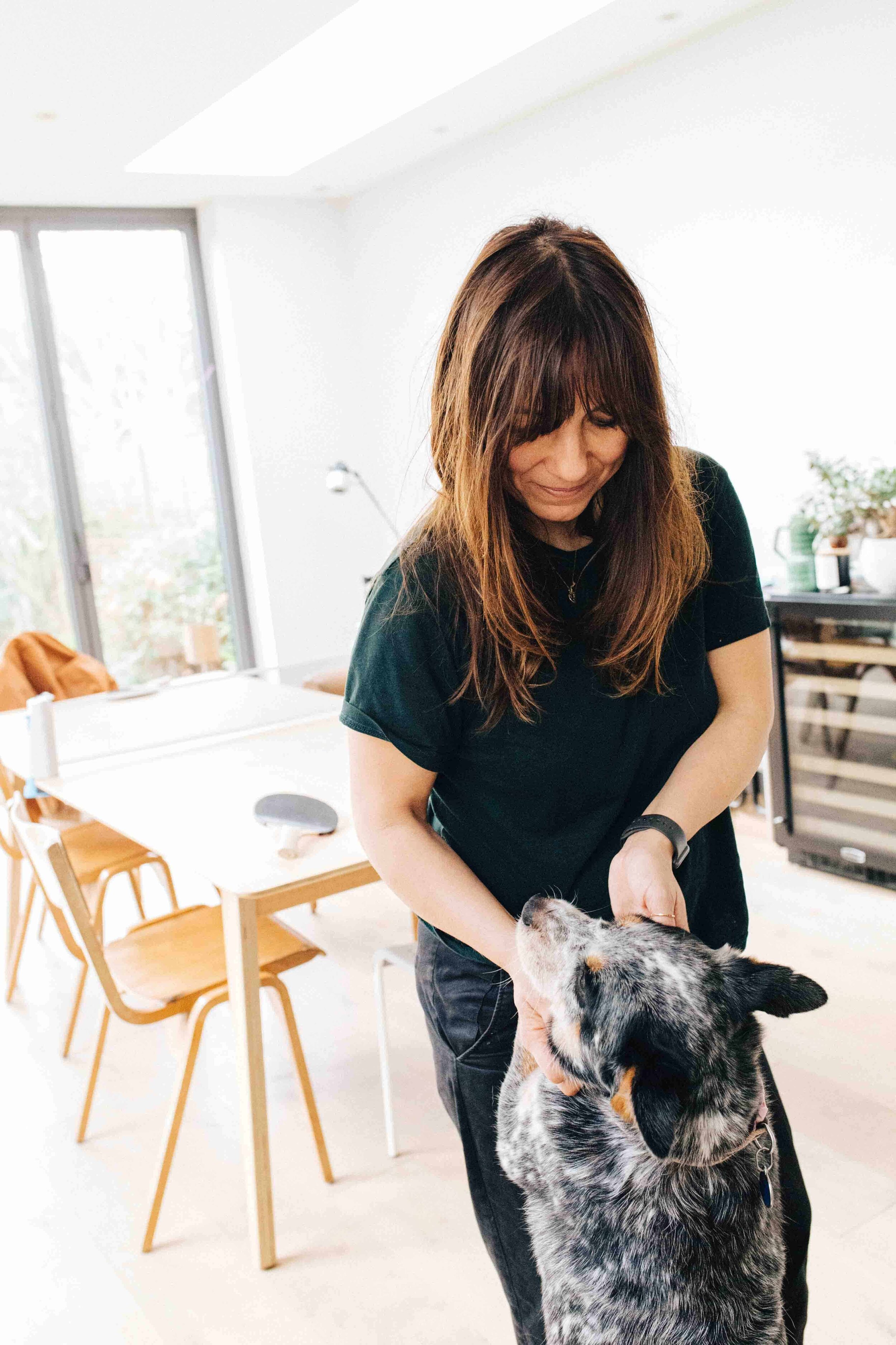 Portrait of artist Jacq Lines at home with her dog