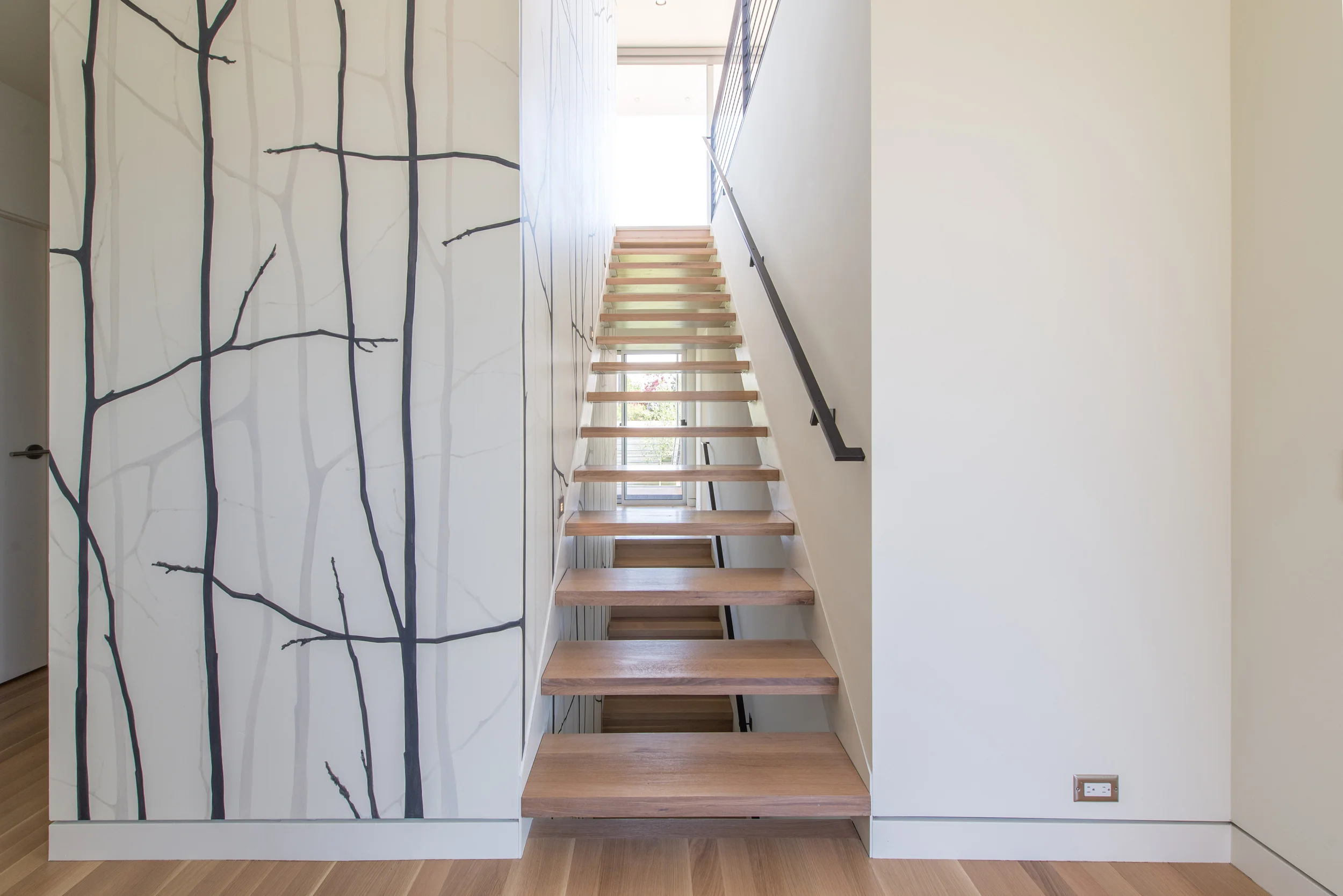 The final look. It turned out beautiful and we are all so happy with the results! This is the main entry. My custom painting extended from below these stairs into the basement, up into this floor, around the hallway to the left, then up the stairs into the kitchen/dining/living room areas. Photo by BUILD LLC.