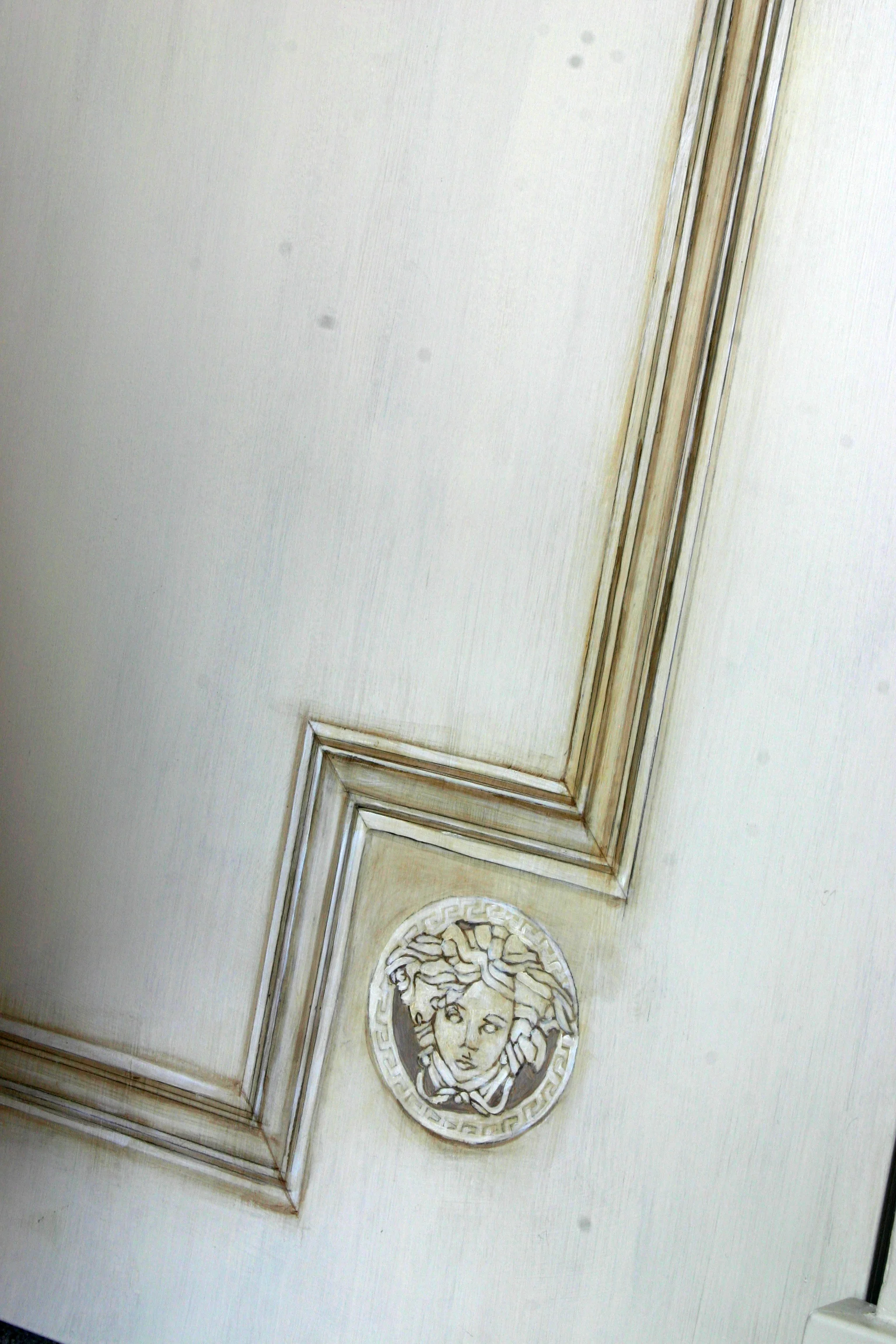 Faux painted Versace Medusa heads and millwork on flat paneled closet doors.