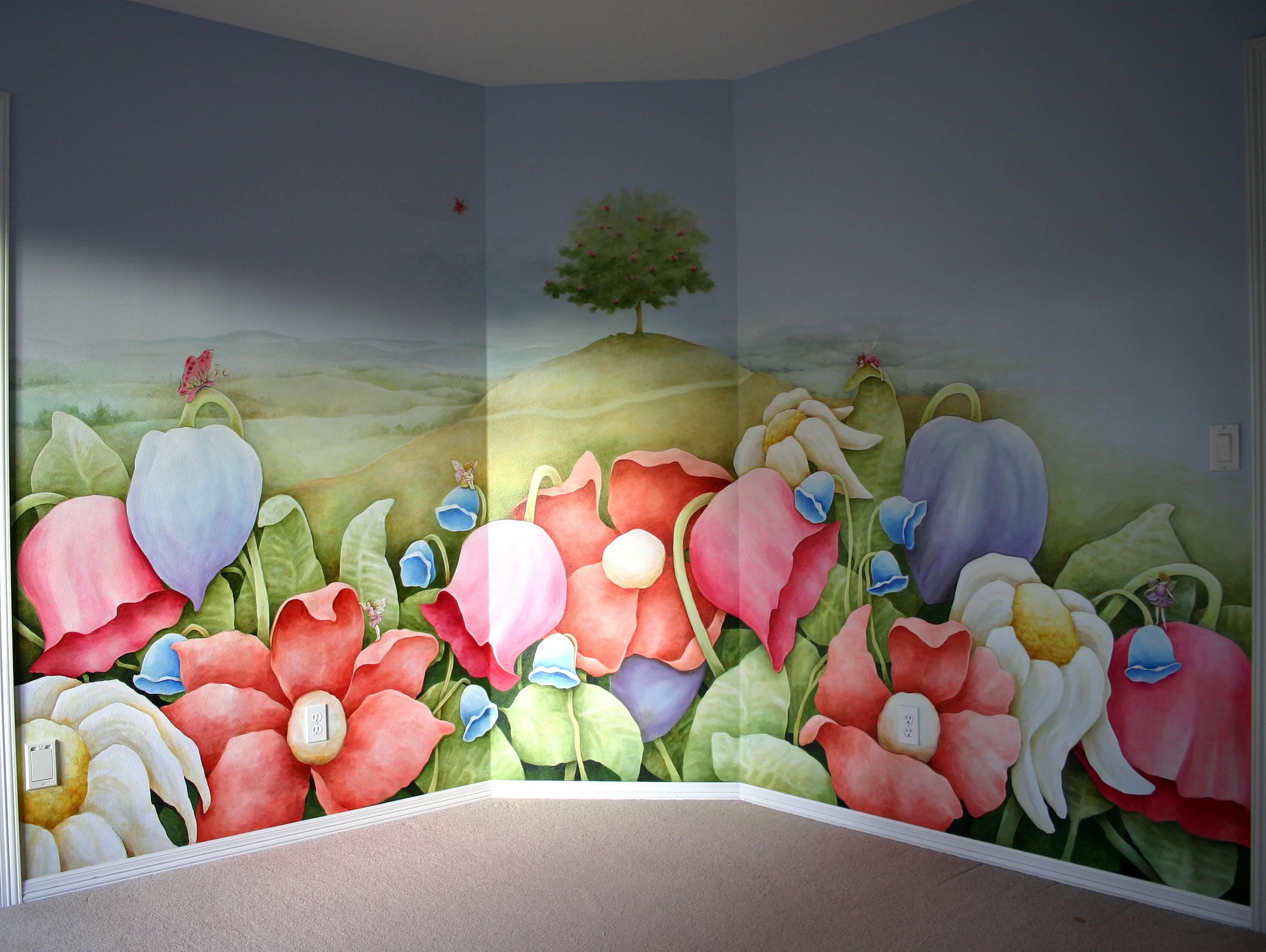 Huge flowers with a tree in the distance painted on a child's bedroom wall.