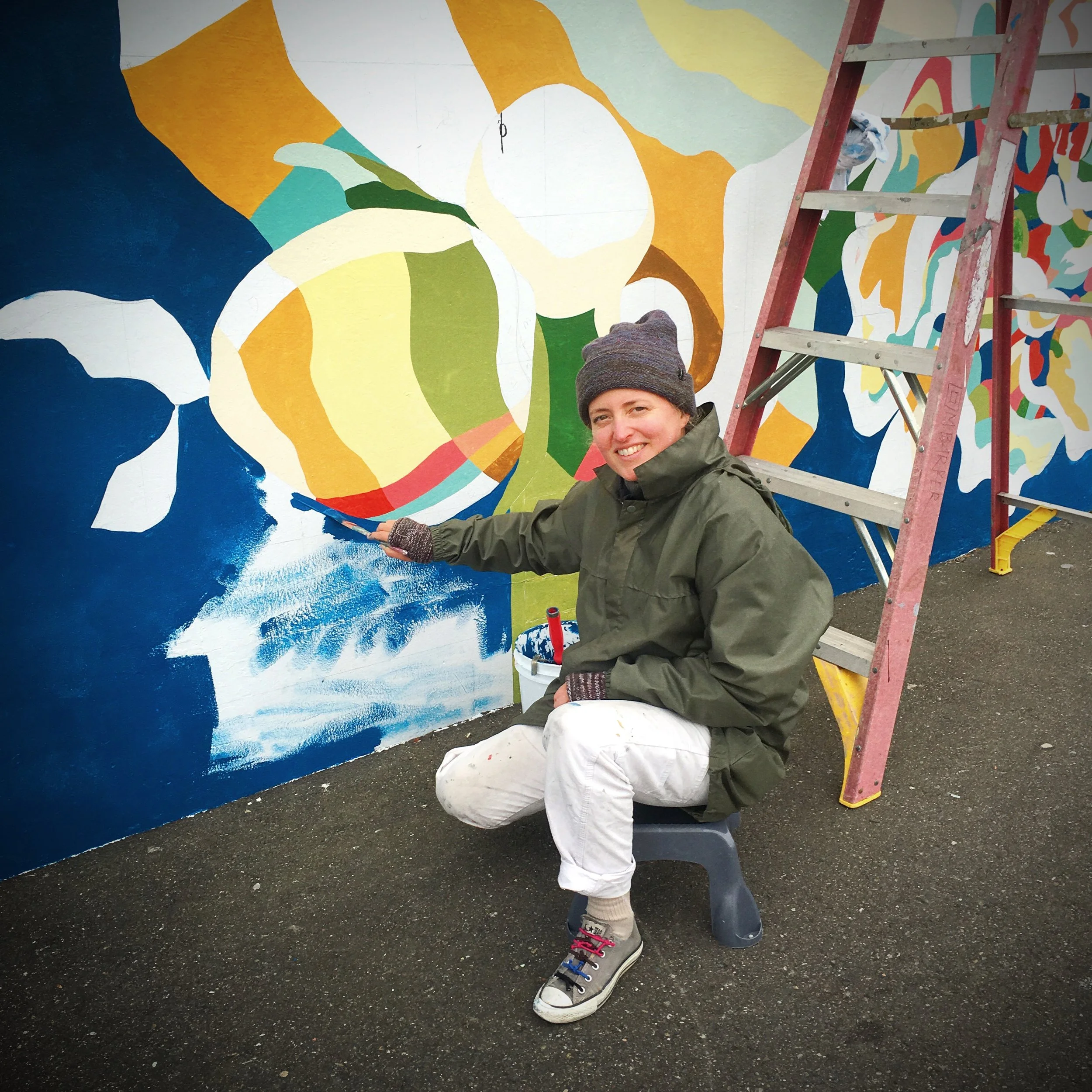 Painting on the mural with pots of color.