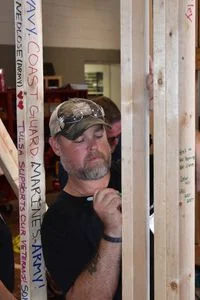 Sparky Gibson, a below-the knee amputee and a retired Marine Corps master sergeant, left a note of encouragement Friday on the frame of a house going to a local homeless veteran. The house was built at the Indian Capital Technology Center. Gibson wrote, "A home built with love to a veteran who gave so much."