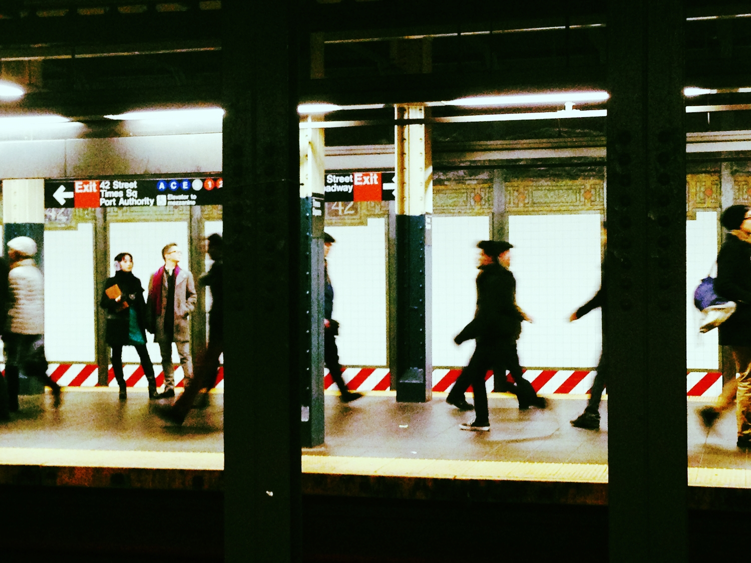 In the bowels of the NYC subway system, love blooms. Check out the fashionable duo on the left.