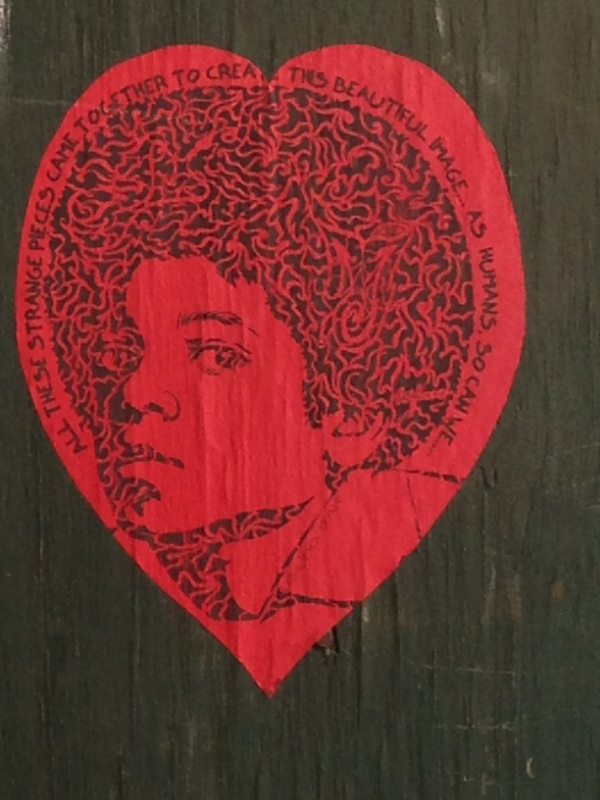 I found this on a construction site in Manhattan. It reads, "All these strange pieces came together to create this beautiful image. As humans, so can we..."