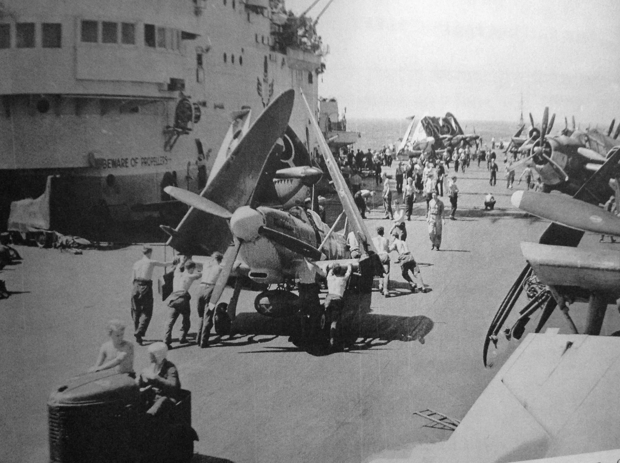 .A Seafire is pushed into position as a strike of the light fighter and Avengers if formed aboard HMS IMPLACABLE.