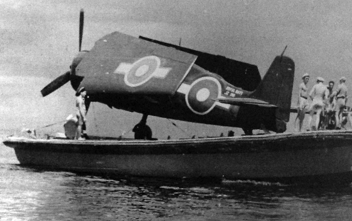 A Hellcat is moved aboard a lighter at Leyte.