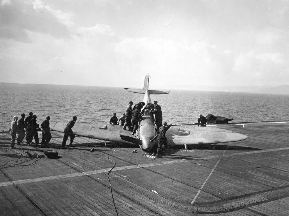 A Seafire after taking the crash barrier aboard the escort carrier HMS RAVAGER.