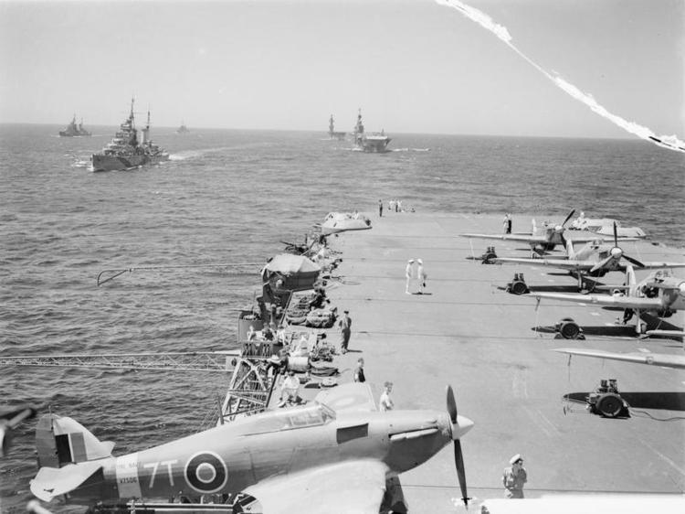 A Sea Hurricane on an outrigger aboard HMS VICTORIOUS, with HMS SIRIUS, PHOEBE, INDOMITABLE and EAGLE following.