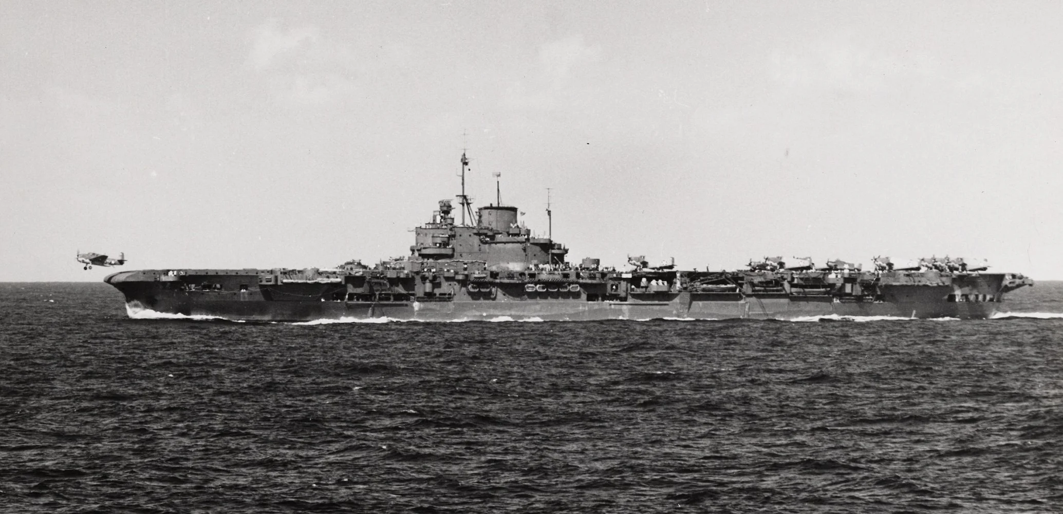 'USS ROBIN' (HMS VICTORIOUS) flies off a Martlet. Avengers can be seen in the rear deck park.
