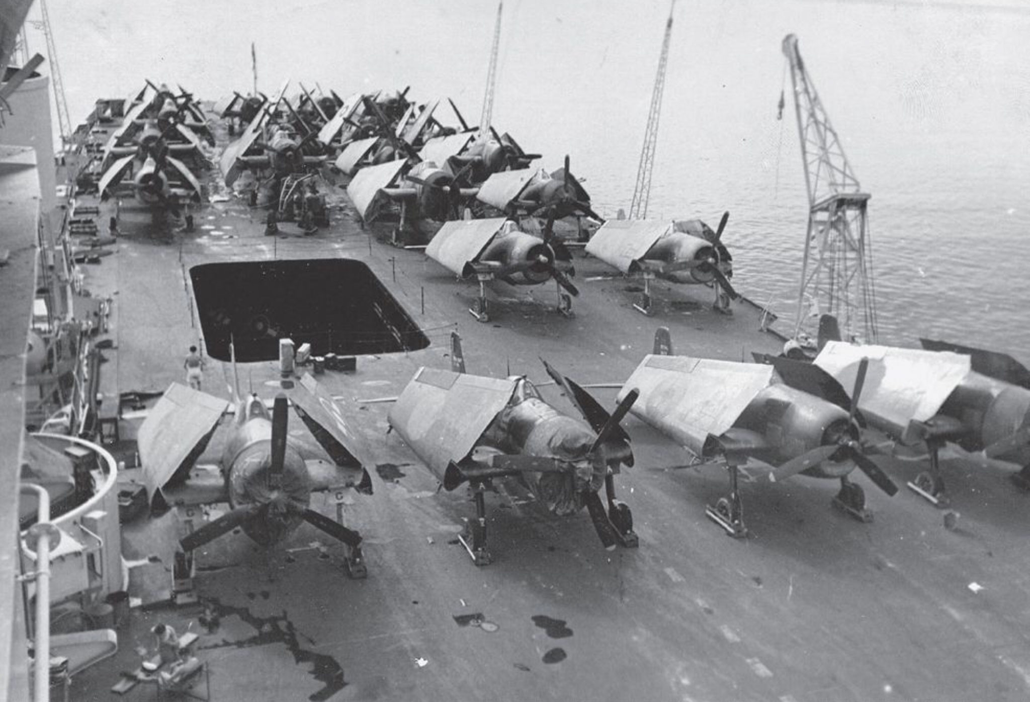 HMS Unicorn in February 1945, carrying spare Hellcat fighters on her flight deck from Ceylon to Australia. Note how the old SEAC roundels have been roughly painted over. In the hangar, as seen through the lift left open for ventilation, can be seen aircraft repainted with the new BPF roundel.