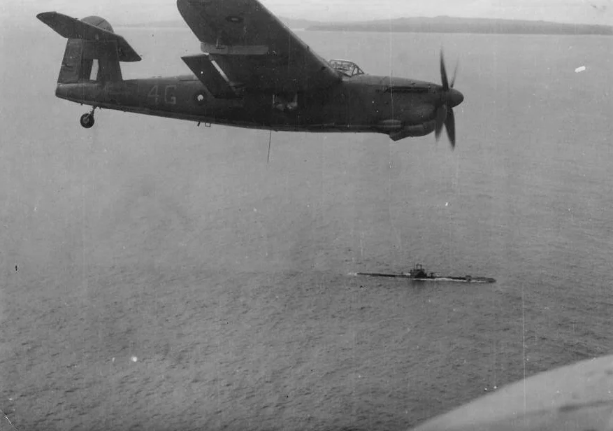 A Barracuda in Eastern Fleet markings flies over an ASR submarine.