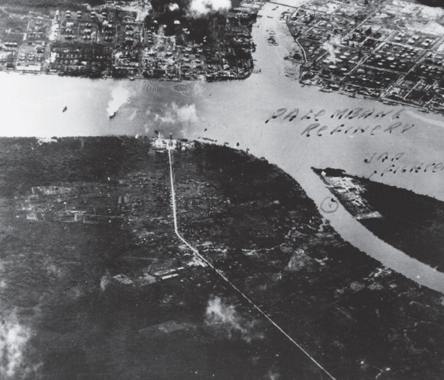 This photograph, taken by Air Coordinator Major Hay during the Meridian II attack on Songei Gerong, has been marked by analysts to highlight the presence of a Japanese fighter. The refinery can be seen burning in the top-left of the image, and the tanker on the left.
