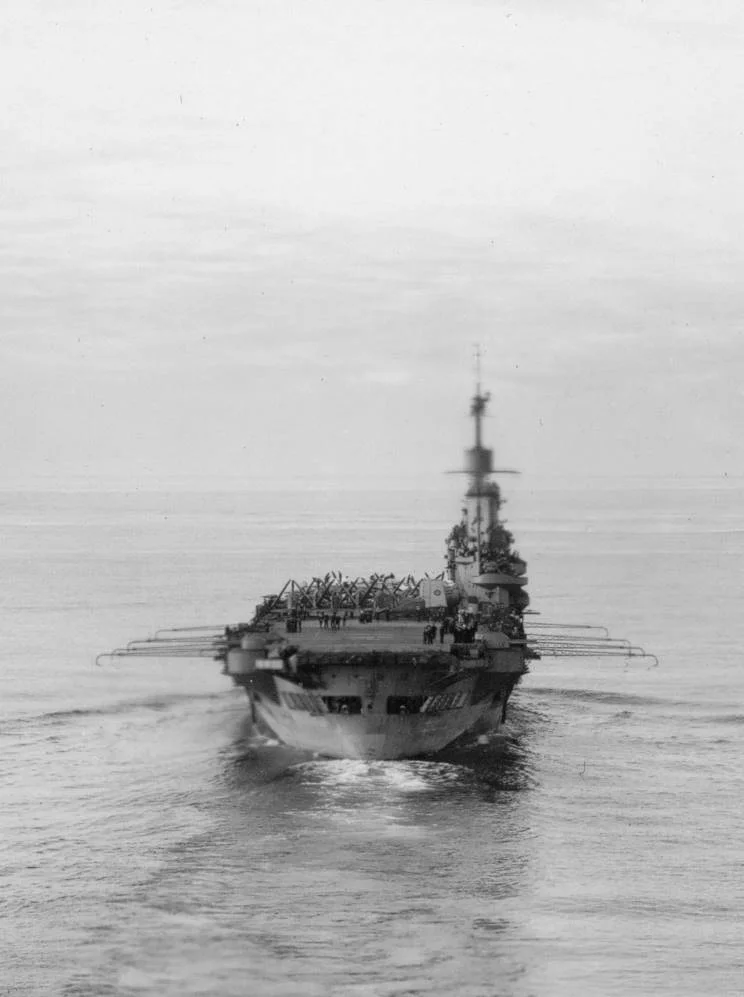 HMS ILLUSTRIOUS, with her deck park crowded amidships.