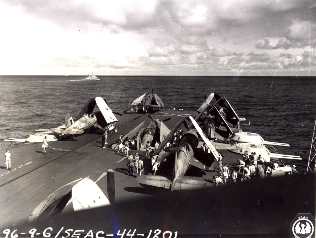Corsairs and an Avenger wait their turn being struck below as another Avenger is lowered on the forward lift.