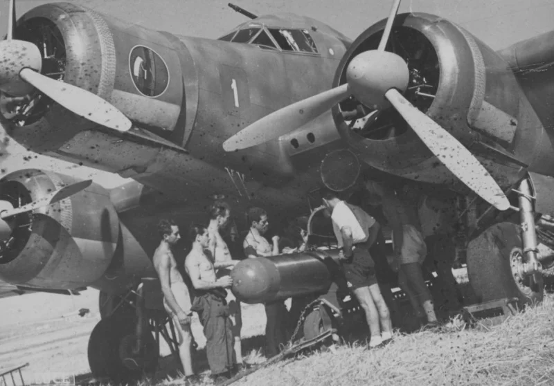 Aircrew fit a torpedo to an S79 Sparviero.