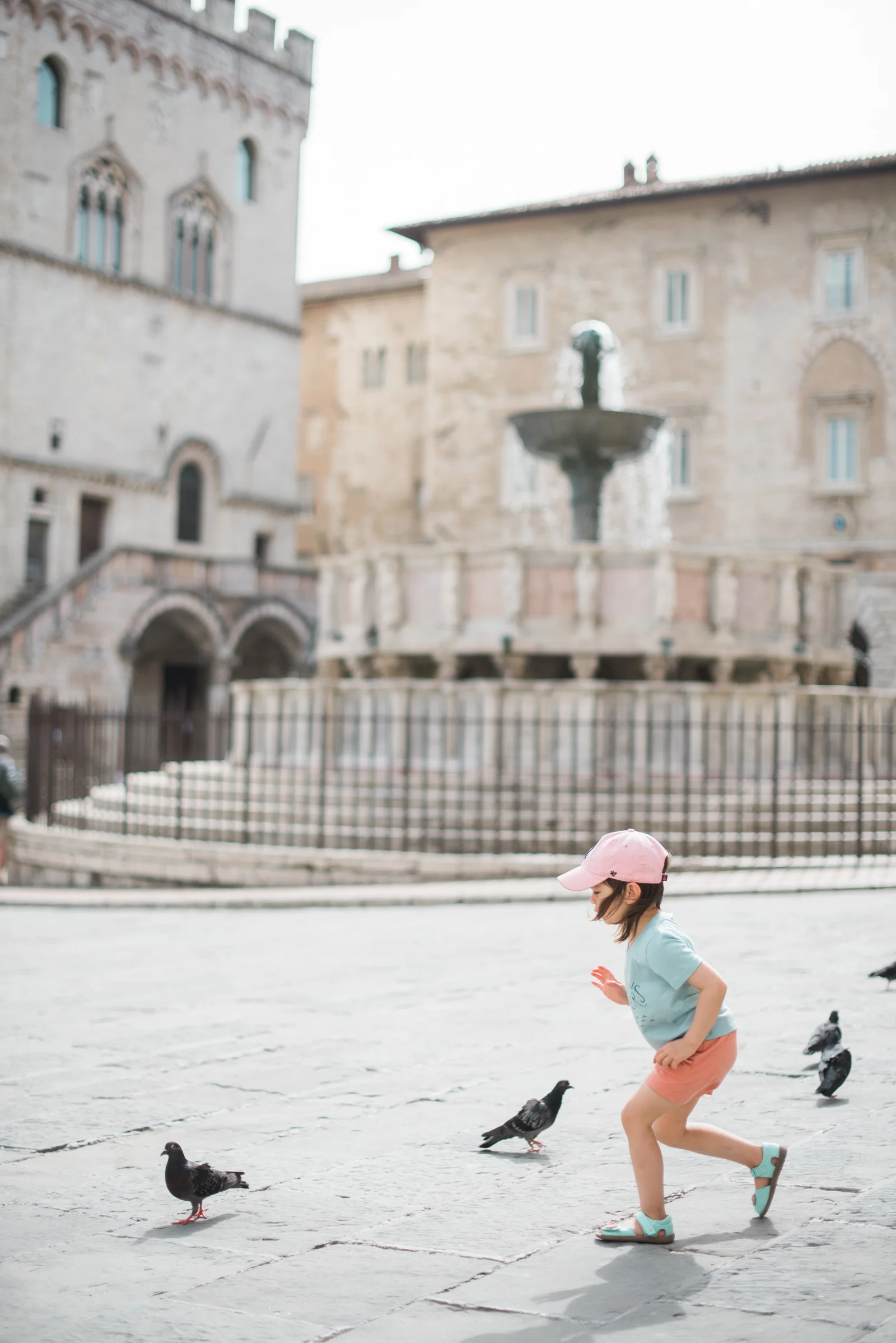 Our little girl, clad in merino and exploring an Italian plaza.