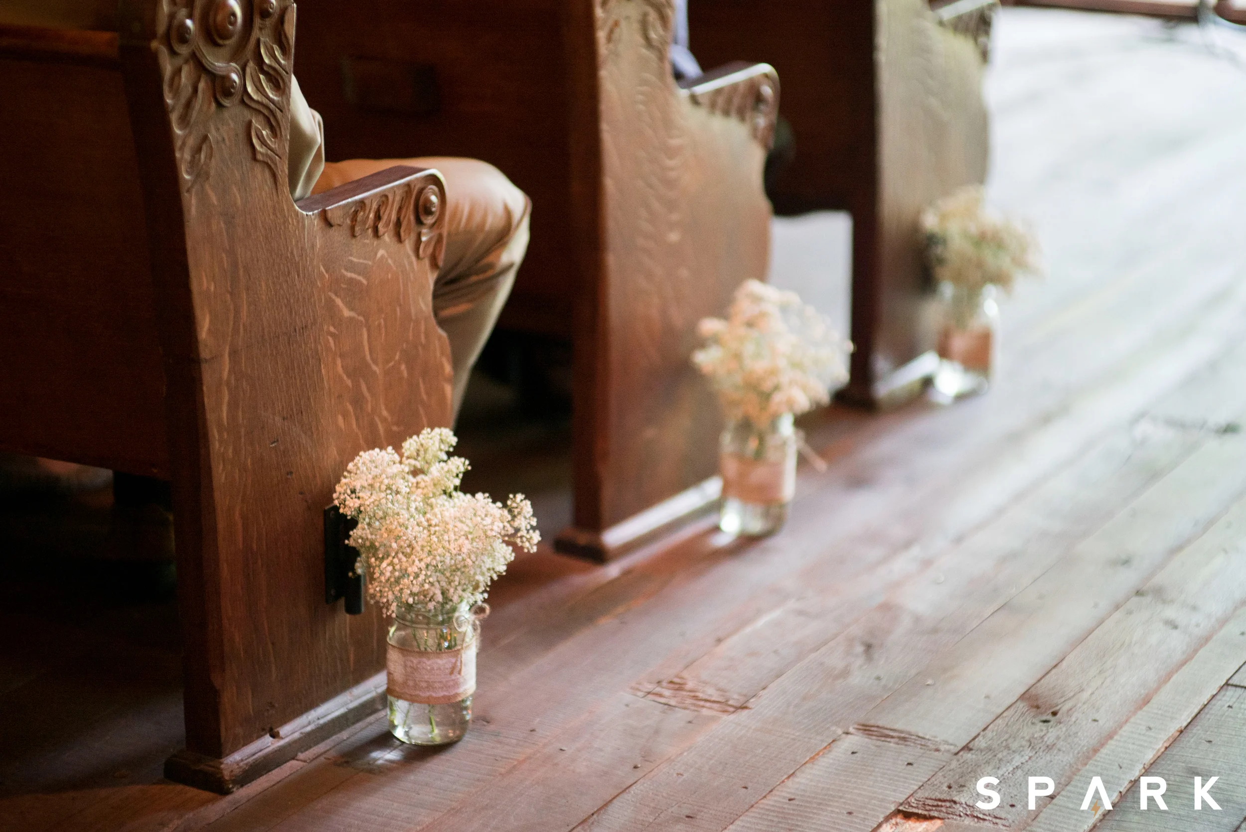Pictured Above : Mason jars filled with baby's breath accented the pews of the Hope Wilderness Chapel at Dogwood Canyon . 