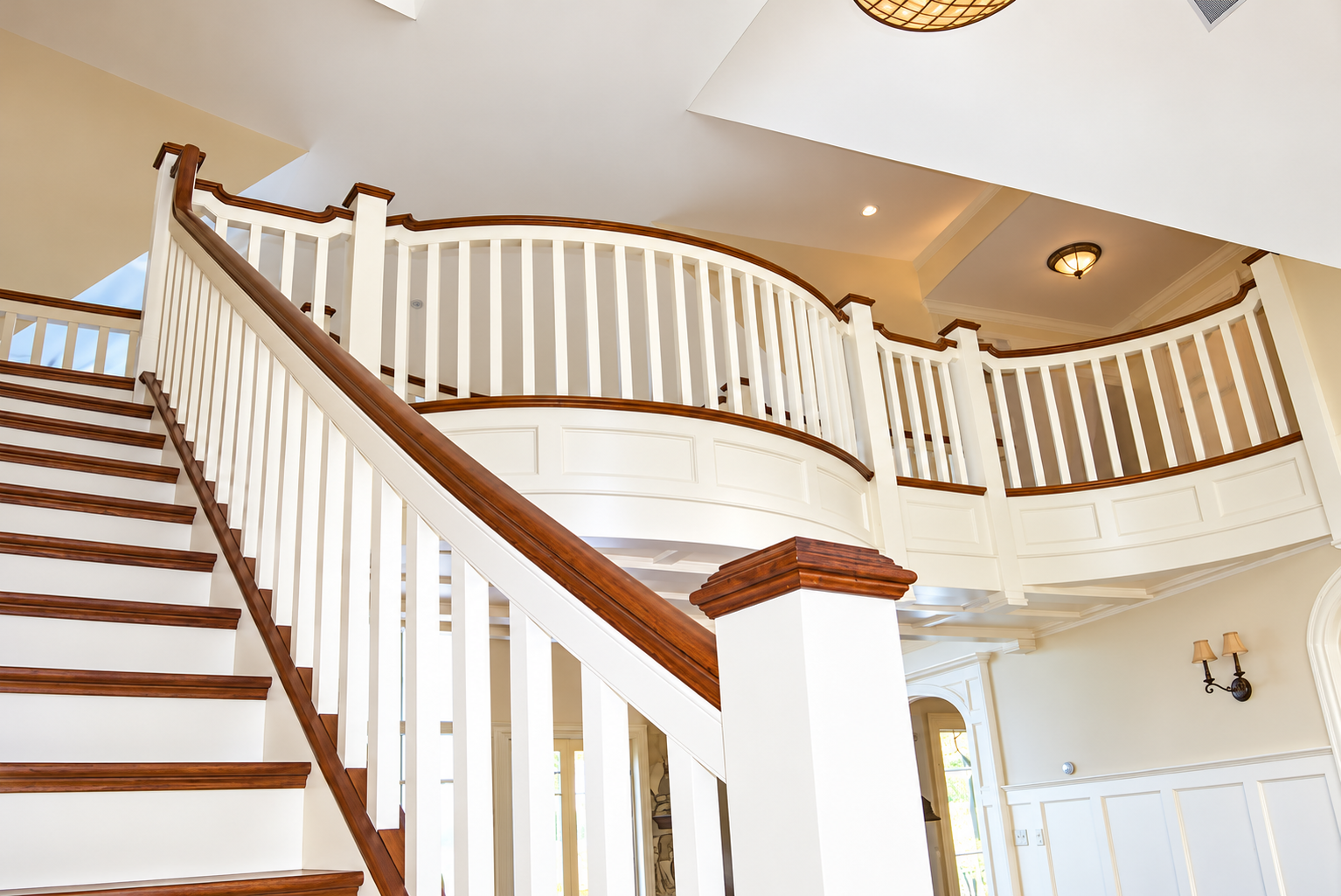 Elegant Curved Staircase and Balcony Foyer.png