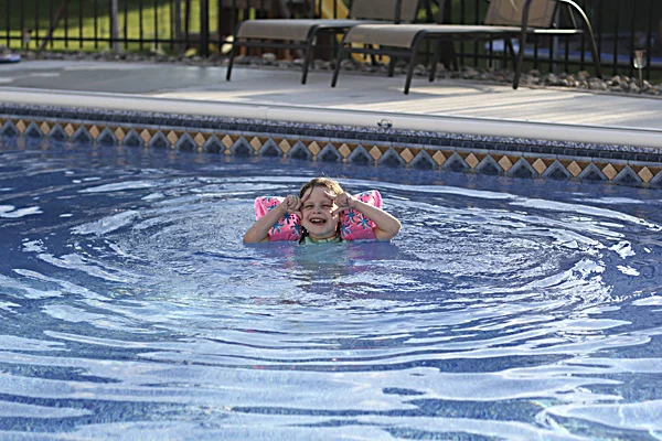 Eva soaking in our friend's backyard pool, and sporting her signature camera pose again. 