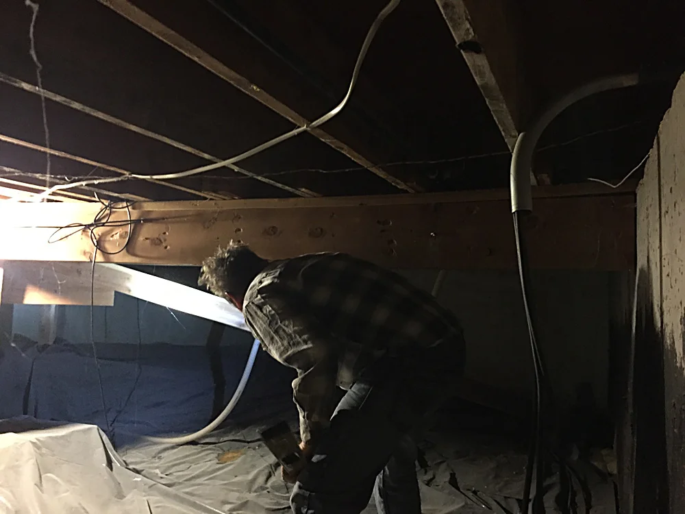 This is a terrible photo, but this this Tom in the crawl space under the office inspecting the structure to see why the office floor bowed. There are plenty of settling issues in this house and we ended up using a jack to shore up this beam.