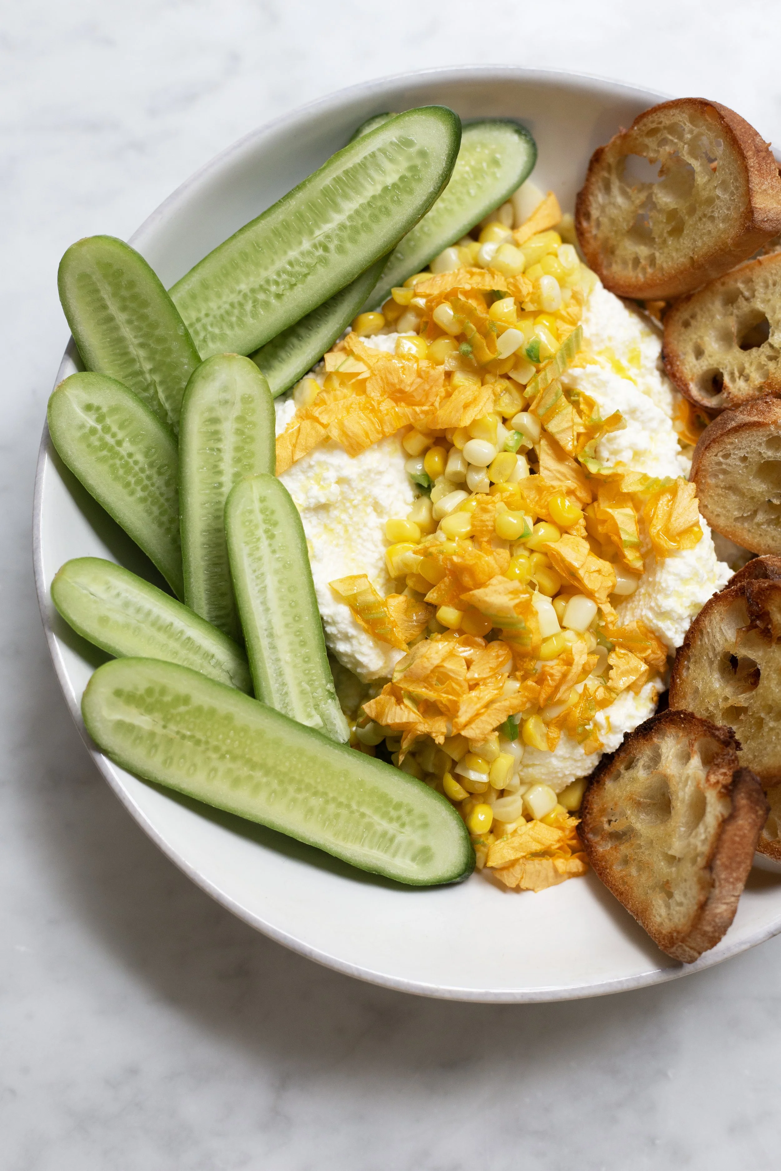 Seared corn over ricotta with squash blossoms