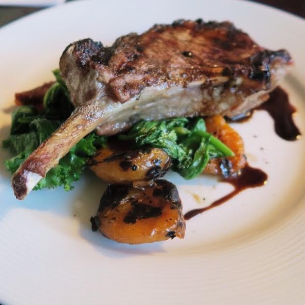 Grilled Kurobuta Porkchop served with mustard greens, grilled apricots, and date purée, vincotto.