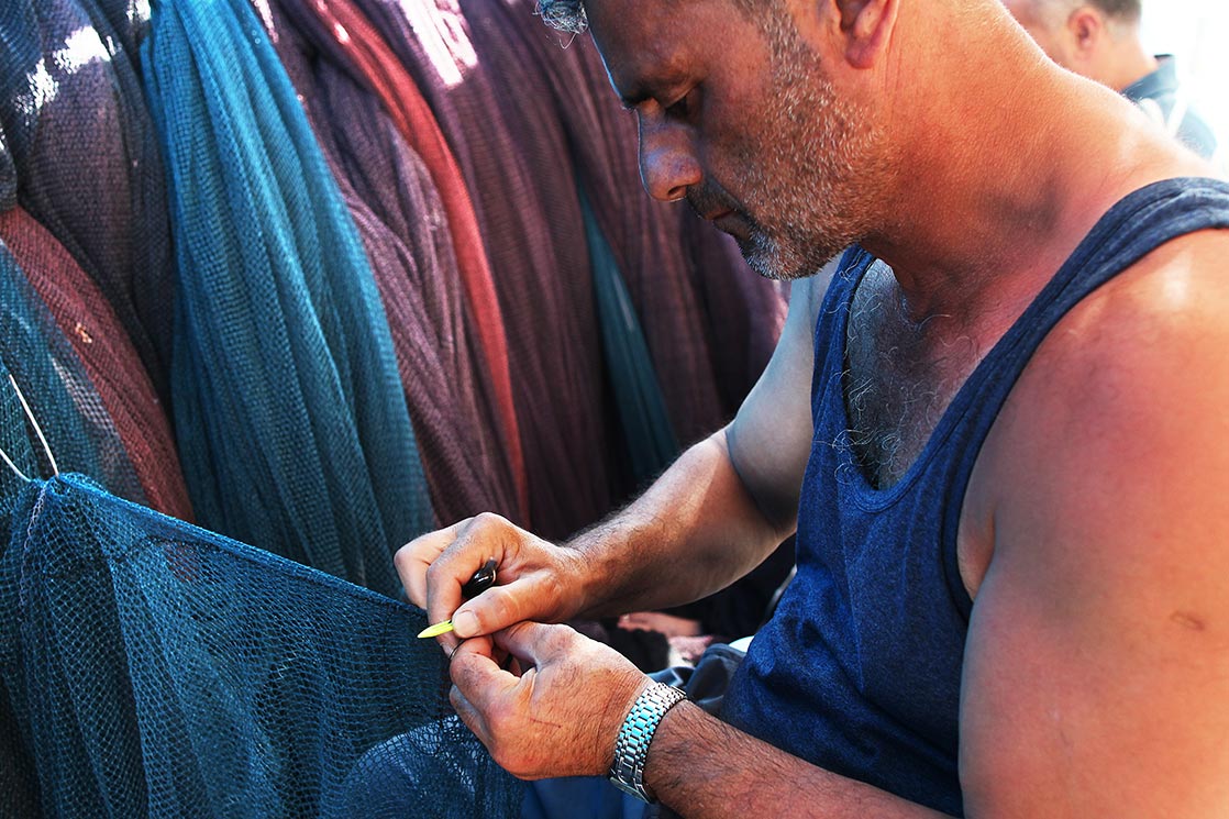 A fisherman mending his net in Sinop harbor | TURKEY
