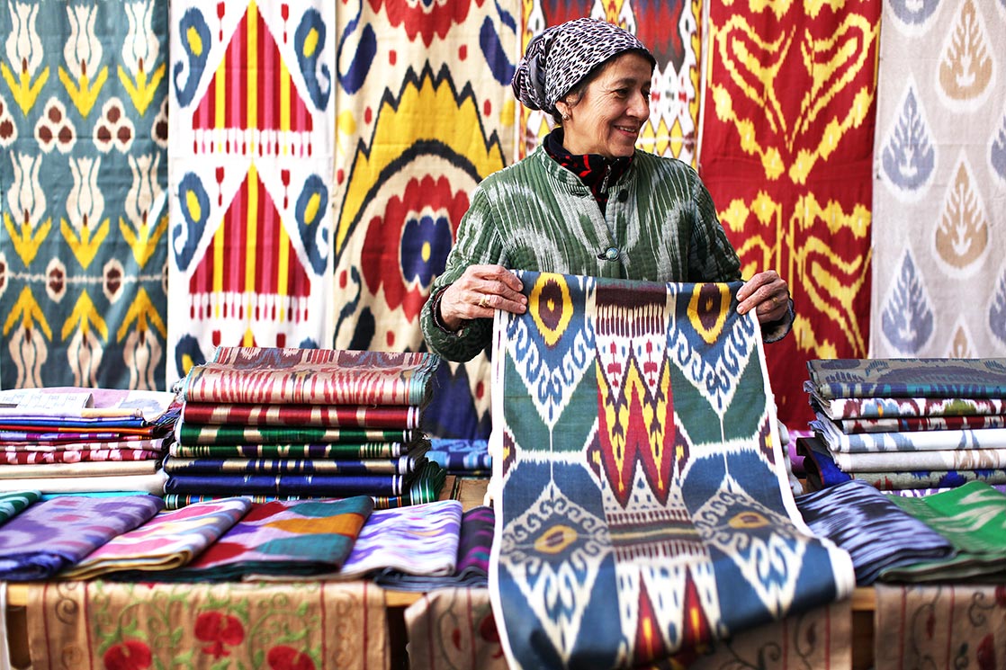 A woman who sells silk fabric in the streets of Bukhara | UZBEKISTAN