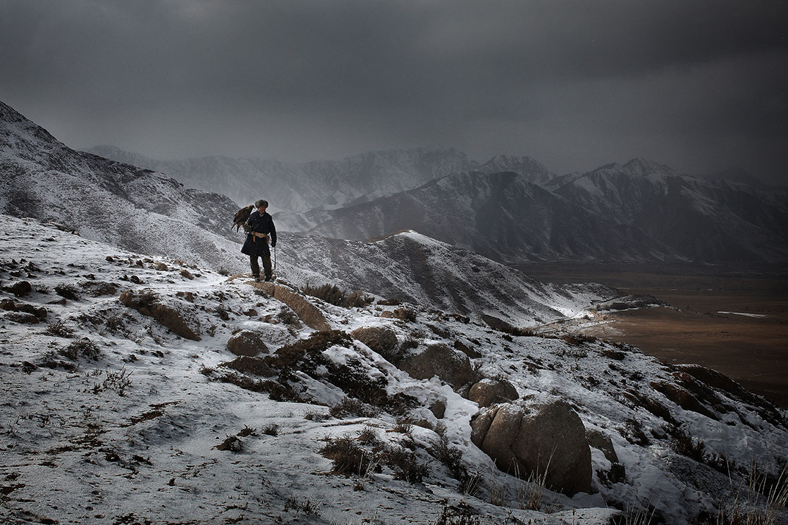 Hunting scenes during winter in Kirgizstan. It is -25°C in Bokonbayevo, but that doesn’t keep the falconers from hunting wolves and foxes. Hunters from one generation to the next, the boys follow their fathers with a falcon on their arm. Here is Azim, 10 years old and proud despite the cold. On his left is his father Talgarbek, 39 years old, carrying Toumara, a female eagle with a wingspan of almost two meters | KYRGYZSTAN