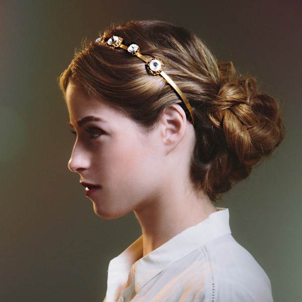 Romantic Bun Add a touch of classic polish to an ultrafeminine look with a simple button-up and deep plum lipstick. Step 1: Create a center part and loosely curl hair outward with a 1-inch wand. Step 2: Bring hair to the nape of the neck, secure into a loose ponytail and braid from the base to ends. Step 3: Wrap braid around the base of the ponytail and pin in place. Step 4: Finish with a firm-hold hair spray and the headband .