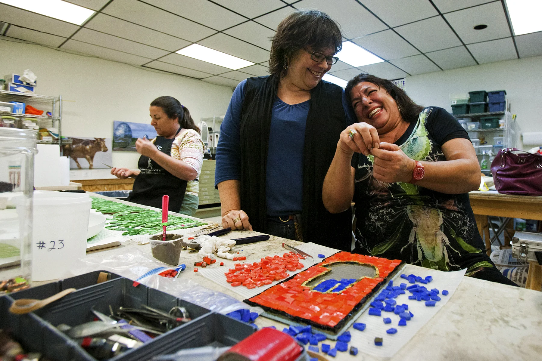 Ginette Jordan (right) and Dianne Sonnenberg (middle) share a laugh on Nov. 7, 2012 as they work on mosaics to celebrate 25 years of pet therapy at Dell's Children Hospital in Austin, Texas.