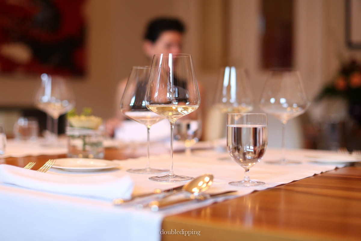 A carefully set table with elegant china and delicate wine glasses