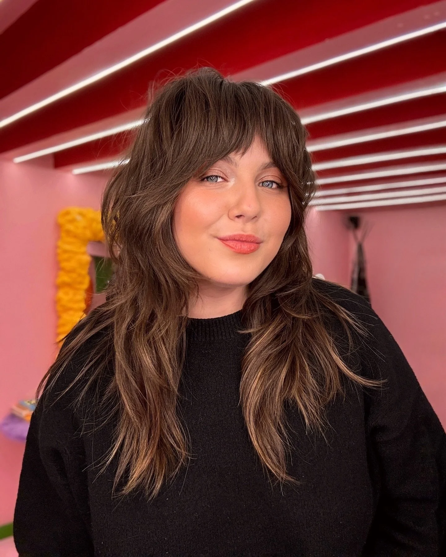 Long brown razor-cut shag with a full fringe and face-framing layers
