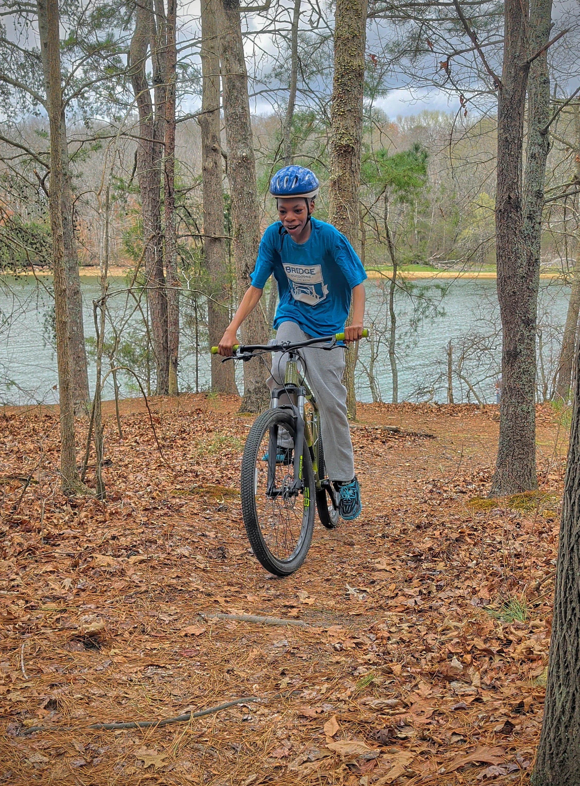 Boy Riding Mountain Bike at Booker T. Washington State Park with Lake in the background