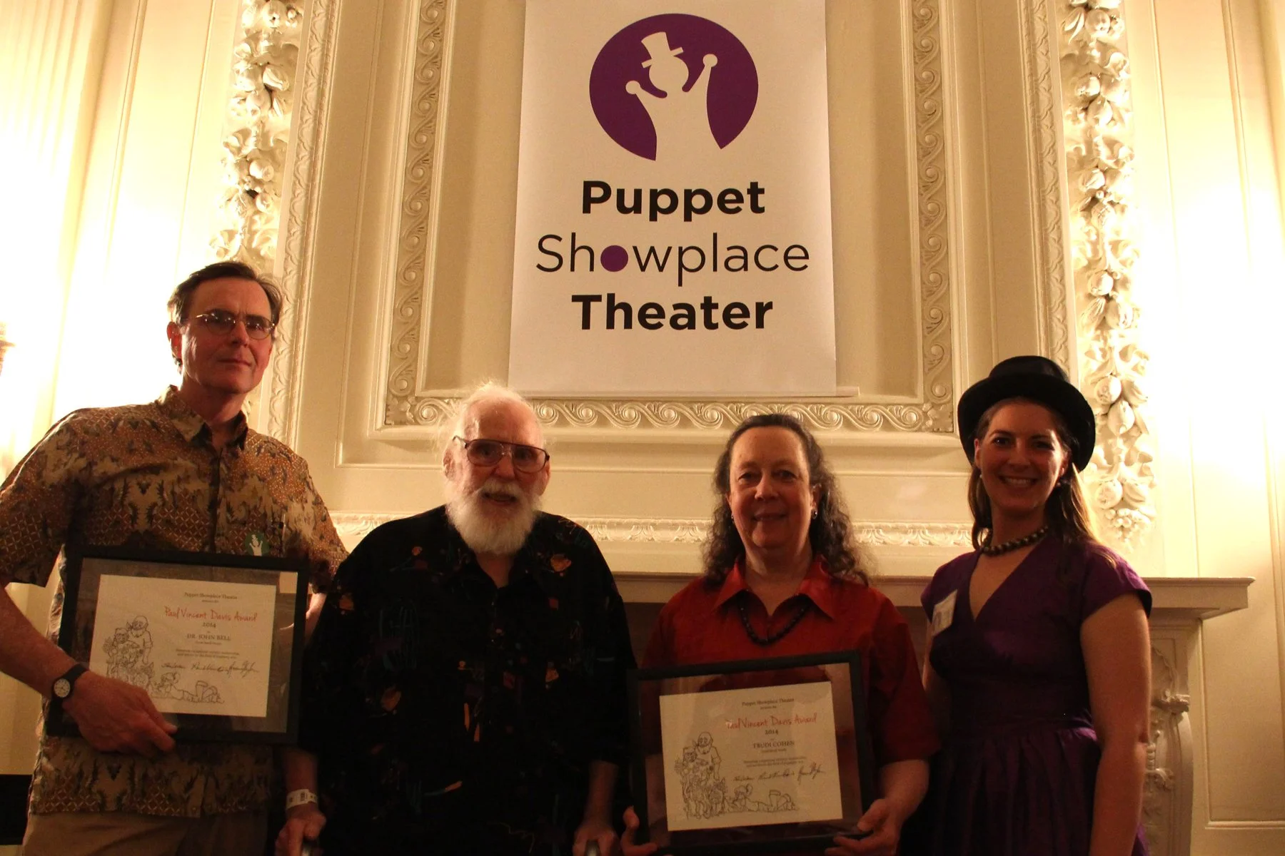 From Left: Puppeteer Dr. John Bell, Paul Vincent Davis, puppeteer Trudi Cohen, and Puppet Showplace Theater’s former artistic director Roxie Myhrum pose at Puppet Showplace Theater’s 40th Anniversary Gala c. 2014. Bell and Cohen were the recipients