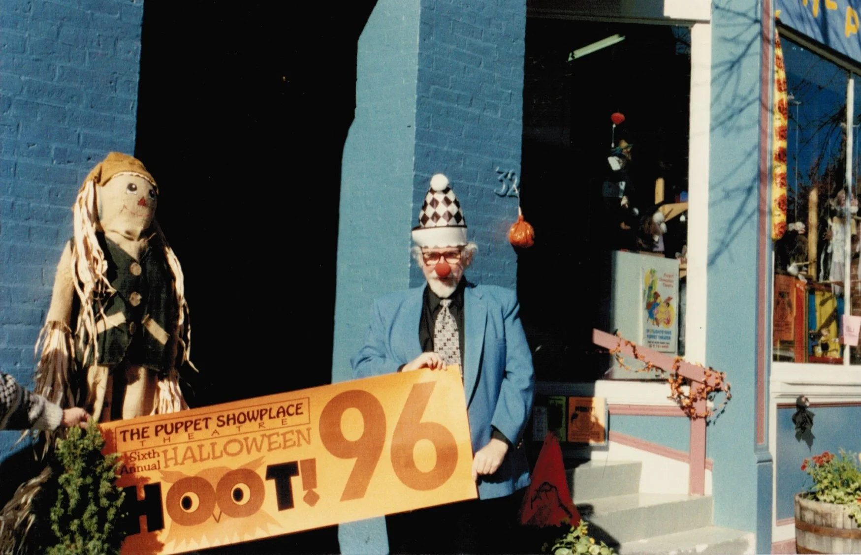 Paul Vincent Davis outside of Puppet Showplace in 1996, holding a sign for Puppet Showplace’s 6th Annual “Halloween Hoot!”